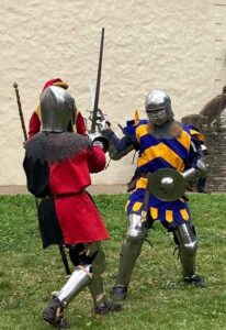 Two armoured knights with bright heraldry battle each other