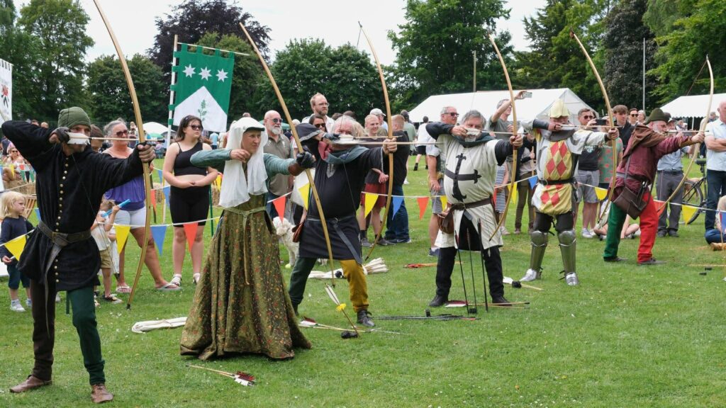 Archers of the Medieval Combat society draw their arrows to shoot the longbow